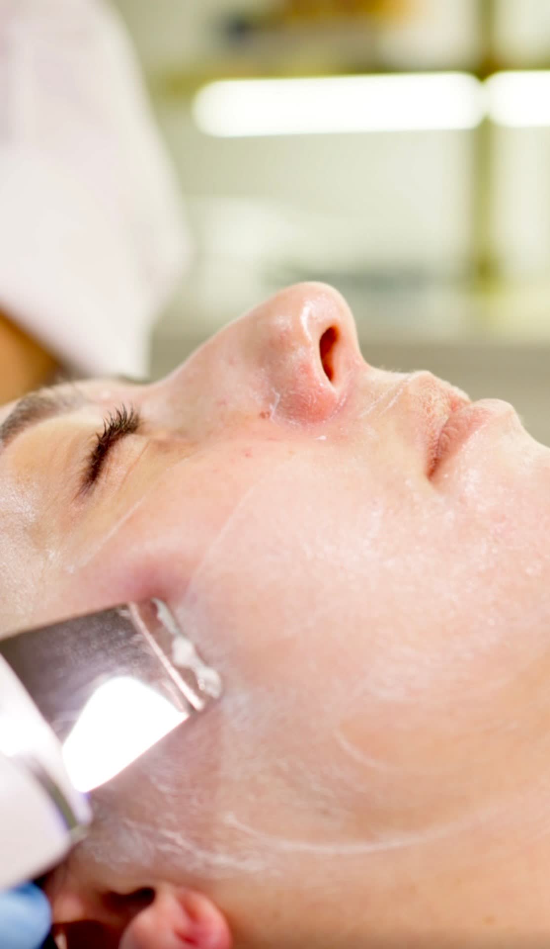 Hands applying a custom-mixed mask during a 60-minute facial